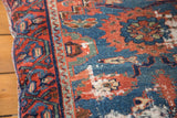 Antique Lilihan floor pillow close-up, revealing age-worn dark blue, red, green floral patterns.