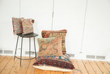 Antique Lilihan floor pillow with dark blue, red, and green patterned rug fragment front.