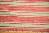 Striped vintage Kilim rug detail in salmon pink and pale green with fringe.
