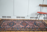 Vintage Malayer runner showing triple medallions, blush rose field, indigo blue abrashes, tattered ends.