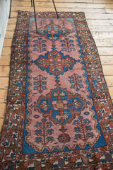 Vintage Malayer runner with tribal motifs, blush rose field, distinct abrashes, and tattered ends.