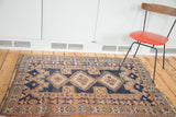 Storied distressed side of an antique Persian Afshar rug, geometric navy and peach patterns.