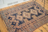 Distressed geometric patterns of an early 20th century Afshar rug in navy and peach.