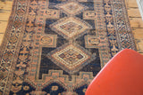 Distressed aesthetic of the antique Afshar rug, with navy, peach, and aqua geometric motifs.