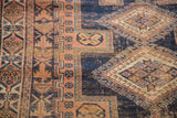 Hand-knotted antique Afshar rug with distressed geometric patterns in navy, peach, and aqua.