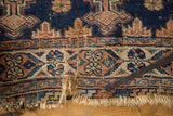 Frayed fringe and distressed end of an antique Afshar rug in navy blue and faded tangerine.