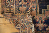 Worn fringe and geometric patterns on the hand-knotted antique Afshar rug foundation.