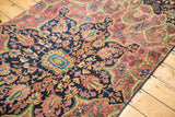 Intricate hand-knotted Farahan Sarouk rug motifs in rose, blue, green, and gold gem tones.