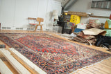 Vintage Distressed Heriz carpet displaying rectilinear medallions and decorative texture in red and navy.