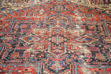Distressed Heriz carpet's rectilinear medallion with germinating flowers and varied texture.
