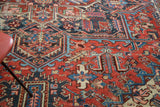 Vibrant red and navy rectilinear design with traditional motifs on a distressed vintage Heriz carpet.