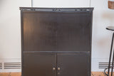 Dark wooden front of the antique hidden bar bureau, showing top sliding door rails.