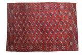 Antique Tekke Bokhara carpet: madder red field, repeating gul motifs featuring mallard green, navy blue.