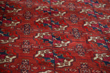 Alternating navy blue and purple within madder red gul motifs of this antique Tekke Bokhara carpet.