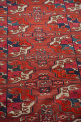 Antique Tekke Bokhara carpet detail: repeating gul motifs with varied madder red, navy, and ivory.