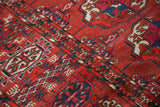 Finely woven antique Tekke Bokhara rug detail; madder red field with alternating guls and geometric borders.