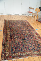 Fringed corner of the antique Persian Malayer runner, showing vibrant herati motifs and borders.