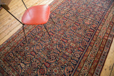 Herati design and vibrant jewel tones on antique Malayer rug's indigo field and geometric border.