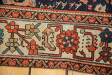 Unique geometric splayed floral motifs on the distressed Malayer rug's ivory border.