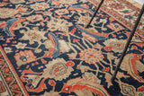 Close-up of distressed antique Malayer rug pile, highlighting navy and coral mahi-mahi herati design.