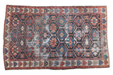 Vintage Distressed Bakhtiari carpet, bold geometric lattice pattern in indigo, red, and faded blues.