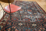 Distressed vintage Bakhtiari rug, bold serrated lattice with geometric flowers, indigo and red.