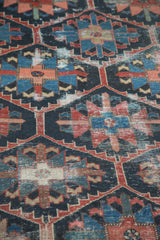 Hard distressed Bakhtiari carpet: geometric flowers in serrated lattice, indigo blue, madder red.