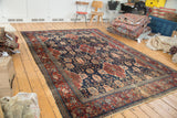 Bold cherry red and rich navy blue floral designs on a distressed vintage Bibikabad carpet.