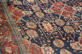Distressed navy blue and cherry red Bibikabad carpet, highlighting the palmette and vine motifs.