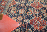 Glossy distressed pile of the Bibikabad carpet, highlighting cherry red and navy motifs.