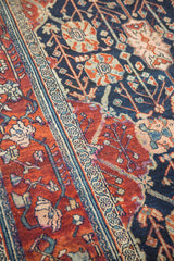 Distressed Bibikabad rug: cherry wine red border meets navy field with floral motifs.