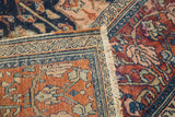 Distressed wool pile showing palmette motifs and intricate borders in cherry wine, navy, peach tones.