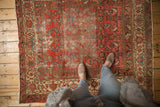 Distressed antique Malayer rug with worn cranberry rose field, Herati pattern, and sky blue accents.