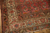 Distressed Malayer rug corner with upbeat cranberry rose field and detailed ivory Herati border.