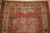 Distressed cranberry rose field of antique Malayer rug with sky blue Herati designs and textured wear.