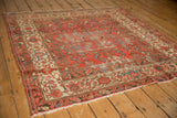 Distressed antique Malayer rug corner, showing decorative ivory border and cranberry rose field.