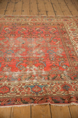 Worn cranberry rose antique Malayer rug showing distressed Herati motifs and exposed foundation.