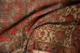 Close-up of distressed antique Malayer rug, showing cranberry field, visible foundation, and herati border.