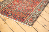 Distressed antique Persian Hamadan runner: brick red herati motif, worn pile, beige floral border.