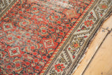 Distressed antique Hamadan runner detail: textured brick red herati motif and meandering beige border.