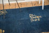 Distressed cobalt blue field and scattered floral motif on this antique Peking rug.