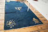 Distressed cobalt blue field of a Chinese Peking runner with beige floral and vase motifs.
