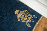 Ornamental vase motif in light brown on the cobalt blue field of an antique Peking rug.