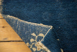 Hand-knotted construction and reverse floral pattern of an antique cobalt Peking rug.