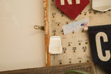 Antique beveled glass mirror, irregular bell shape, copper wire, spotted discoloration.