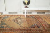 Distressed Halvei Bijar rug with an expressive medallion, open camel field, and colorful borders.