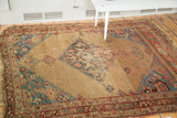 Distressed camel field, expressive aqua blue corner, and colorful border detail of antique Halvei Bijar rug.