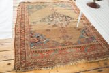 Distressed antique Halvei Bijar rug corner with faded red-orange border, teal patterns, and fringe.