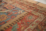 Distressed Persian Halvei Bijar rug section with rustic geometric and stylized floral patterns.