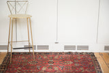 Sprawling floral motifs on the soft red pile of a distressed antique Sarouk rug.